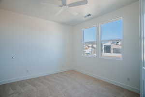 Unfurnished room featuring light carpet and ceiling fan