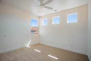 Spare room with light carpet and ceiling fan