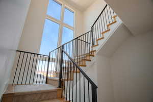 Staircase featuring healthy amount of natural light and a high ceiling