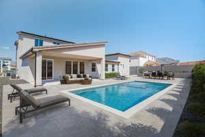 Back of house featuring an outdoor hangout area, a patio area, stucco siding, a fenced backyard, and outdoor dining space