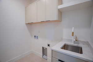 Laundry area featuring hookup for a washing machine, electric dryer hookup, and cabinet space
