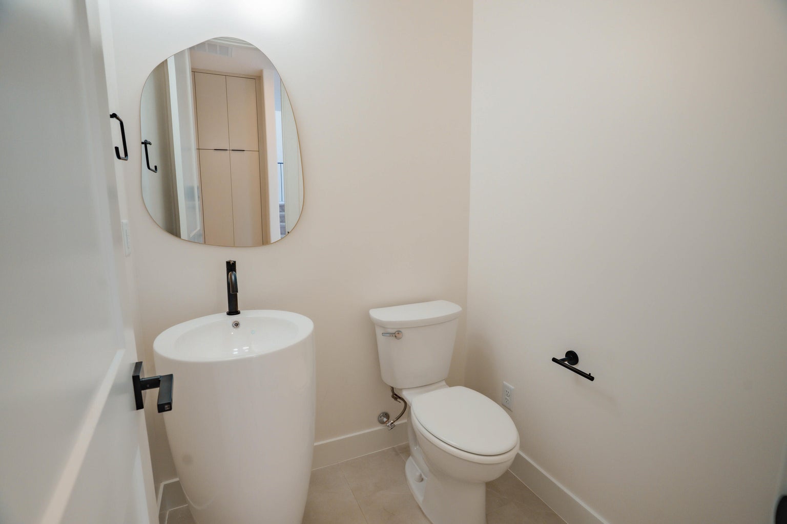 Half bathroom featuring toilet and tile patterned flooring