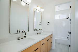 Full bath with double vanity and shower / tub combination