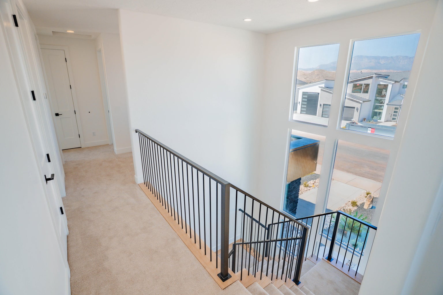 Hall with light carpet, an upstairs landing, and recessed lighting