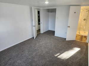 Unfurnished bedroom featuring carpet flooring and a textured ceiling