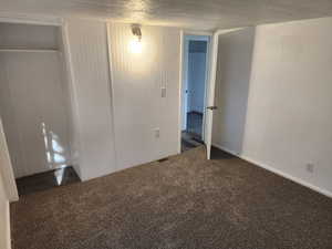 Unfurnished bedroom featuring carpet flooring, a closet, and a textured ceiling