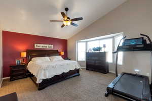 Bedroom with carpet, a ceiling fan, and high vaulted ceiling