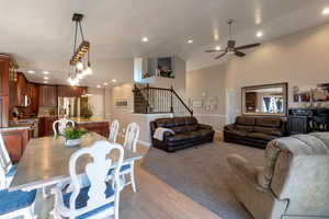 Dining area featuring stairs, high vaulted ceiling, light wood finished floors, light colored carpet, and recessed lighting