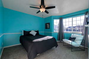 Bedroom featuring a ceiling fan and carpet