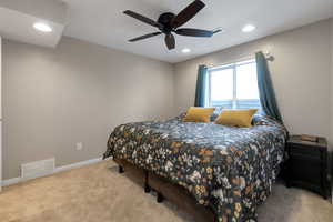 Bedroom with light colored carpet, recessed lighting, and a ceiling fan
