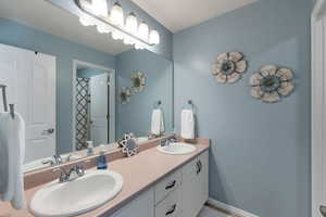 Bathroom featuring double vanity and a shower with shower curtain