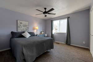 Bedroom featuring carpet, ceiling fan, and a textured ceiling