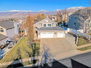 View of front facade with concrete driveway, a mountain view, and a residential view