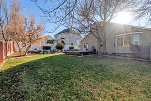 Rear view of house featuring a deck, a fenced backyard, and stucco siding