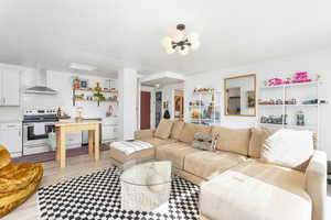 Living room featuring light wood-type flooring and a chandelier