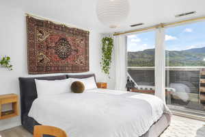 Bedroom with wood finished floors and a mountain view