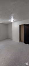 Bedroom featuring a textured ceiling and light colored carpet