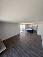Living room with dark wood-style floors and baseboards