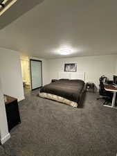 Bedroom featuring an office area and dark carpet