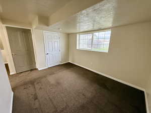 Unfurnished bedroom featuring a textured ceiling and carpet floors