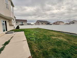 Fenced backyard featuring a patio and a residential view