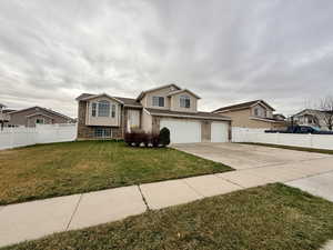 View of front facade featuring brick siding, driveway, and a garage