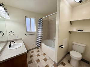 Bathroom with vanity, a textured ceiling, and shower / bath combo with shower curtain