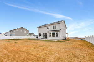 Rear view of house featuring a fenced backyard and a patio area
