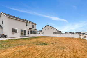 Rear view of house with a patio, a fenced backyard, and stucco siding