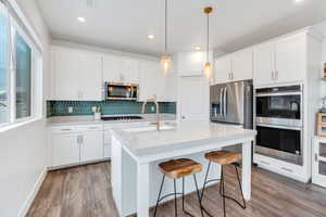 Pristine kitchen offers breakfast bar seating, and stainless-steel appliances