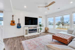 Bright expansive living space with large windows, recessed lighting and ceiling fan