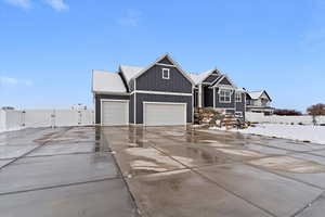 Craftsman house with a gate, board and batten siding, driveway, and a garage