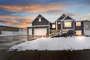 View of front of home featuring concrete driveway, a gate, and board and batten siding