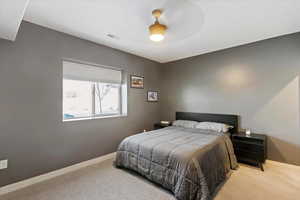 Carpeted bedroom with baseboards and a ceiling fan