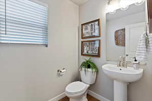 Half bathroom with baseboards and toilet