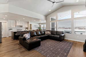Living area with recessed lighting, light wood finished floors, ceiling fan, and lofted ceiling