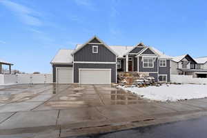 View of front of home featuring board and batten siding, concrete driveway, a gate, and an attached garage