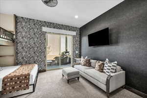 Living room with wallpapered walls, carpet flooring, and recessed lighting