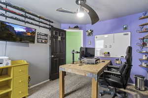 Office with ceiling fan and light carpet