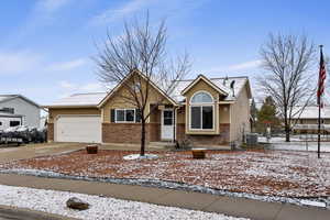 View of front of home featuring brick siding, driveway, and an attached garage