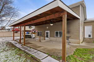 Back of house with ceiling fan and a patio