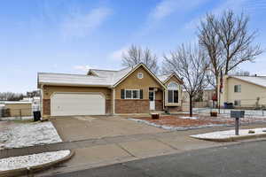 View of front of home featuring brick siding, concrete driveway, an attached garage, and a shingled roof