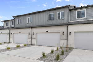 Traditional-style house featuring concrete driveway, stone siding, board and batten siding, and a garage
