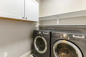 Laundry area with cabinet space and washer and clothes dryer