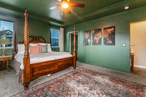 Carpeted bedroom featuring a textured ceiling, a ceiling fan, and multiple windows