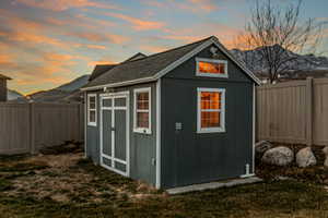 View of shed with a fenced backyard and a mountain view