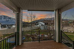Wooden porch featuring a yard, a residential view, and a mountain view