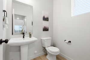 Half bath with baseboards and light wood-style floors