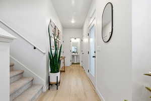 Hall with light wood-type flooring and stairway