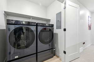 Washroom featuring electric panel and separate washer and dryer